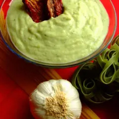 Cremige Brokkoli Sahne Sauce mit getrockneten Tomaten, daneben grüne Tagliatelle, Knoblauch und Spaghetti.