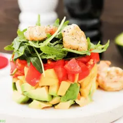 Ein sommerlicher Salat mit Garnelen, Avocado und Tomaten, garniert mit Rucola. Perfekt für heiße Tage!