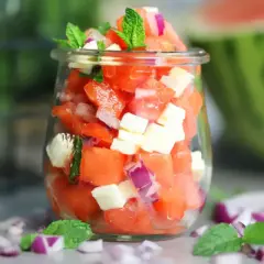 Erfrischender Wassermelonen Salat mit Feta, roten Zwiebeln und Minze in einem Glas. Perfekt für heiße Tage!