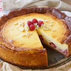 Ein köstlicher Kuchen mit Mascarpone und Himbeeren, garniert mit Mandelsplittern und frischen Beeren.