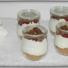 Vier leckere Nachtisch im Glas mit Müsli-Boden, cremiger Füllung und Fruchtpüree.