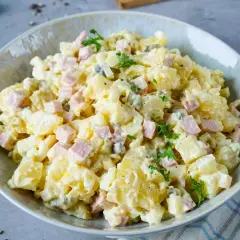 Ein Teller mit Omas Kartoffelsalat mit Mayonnaise, garniert mit Petersilie. Ein Klassiker, der immer schmeckt!
