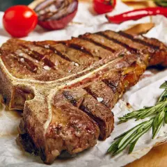 Perfekt gegrilltes T-Bone-Steak mit Rosmarin, Tomaten und Zwiebeln. Ein Genuss für jeden Grillmeister!