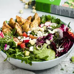 Bunter Salat mit knusprigen Kartoffelspalten, Feta, Radieschen und cremiger Avocado-Dip.