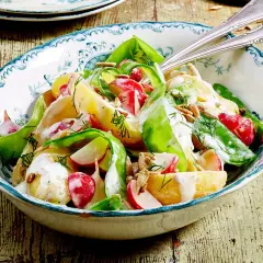 Kartoffelsalat mit Radieschen, Gurke und Dill, verfeinert mit einer cremigen Sauce und Sonnenblumenkernen. Ein frischer Genuss!