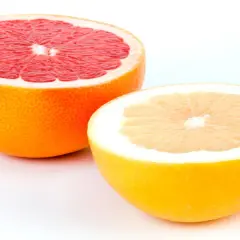 Zwei Hälften von Grapefruits, eine rote und eine gelbe, zeigen, wie man eine Grapefruit schneidet.