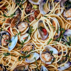 Spaghetti mit Muscheln, ein köstliches Gericht mit zarten Muscheln und perfekt gekochten Nudeln, garniert mit frischen Kräutern.