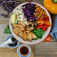 Bunter Bowl mit Reis, Hähnchen, Gemüse und Kichererbsen. Perfekt, um eine leckere bowl sauce selber machen.