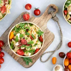 Ein köstlicher mediterraner Salat mit Farfalle, getrockneten Tomaten, frischen Kirschtomaten, Rucola und Feta.