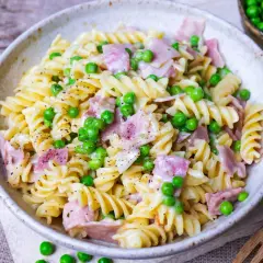 Fusilli-Nudeln mit Erbsen und Schinken in cremiger Schinken Sahne Sauce, bestreut mit schwarzem Pfeffer.