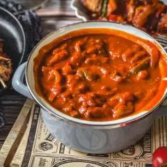 Herzhafte schaschlik sauce wie im imbiss, mit Fleischstücken und Paprika, dane daneben gegrillte Spieße.