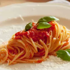 Ein Teller Spaghetti mit einer leckeren Tomatensauce, garniert mit frischem Basilikum und Parmesan. Ein Klassiker der italienischen Küche.
