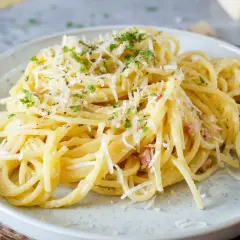 Ein Teller cremiger Spaghetti Carbonara, garniert mit Parmesan und Petersilie. Perfekt für einfache spaghetti rezepte.