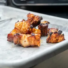 Knuspriger bauchspeck im airfryer, goldbraun und perfekt gegart, liegt auf einem Blech. Ein Genuss für jeden Fleischliebhaber!