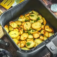 Goldbraune bratkartoffeln im Airfryer, garniert mit frischer Petersilie. Perfekt als Beilage oder Snack.