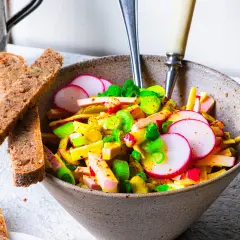 Schmackhafter Schweizer Wurstsalat mit Radieschen und Lauchzwiebeln, serviert mit Vollkornbrot. Ein tolles Rezept für den Sommer!