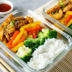 Gesunde meal prep rezepte: Hähnchen mit Paprika, Brokkoli und Reis in Glasbehältern. Perfekt für unterwegs.