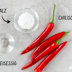Zutaten für ein Sambal Oelek Rezept: rote Chilischoten, Salz und Reisessig.