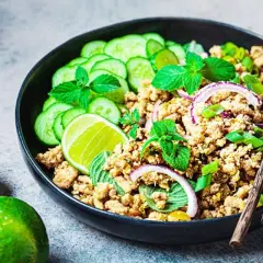 Würziges Laab Gai Rezept: Hackfleisch mit Gurkenscheiben, Minze, Limette und Zwiebelringen in einer Schüssel, bereit zum Genießen.