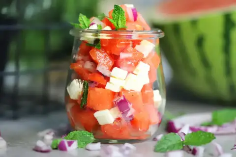 Erfrischender Wassermelonen Salat mit Feta, roten Zwiebeln und Minze in einem Glas. Perfekt für heiße Tage!