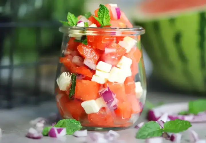 Erfrischender Wassermelonen Salat mit Feta, roten Zwiebeln und Minze in einem Glas. Perfekt für heiße Tage!