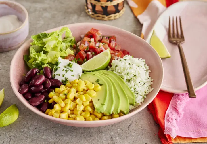 Buntes Burrito Bowl Rezept mit Reis, Bohnen, Mais, Avocado, Salsa und Salat. Ein köstliches und gesundes Gericht.