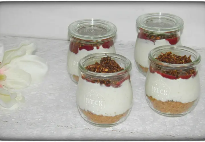Vier leckere Nachtisch im Glas mit Müsli-Boden, cremiger Füllung und Fruchtpüree.