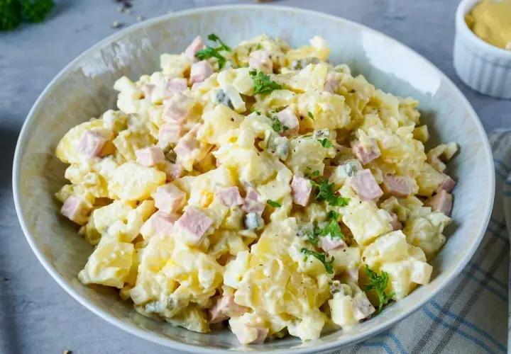 Ein Teller mit Omas Kartoffelsalat mit Mayonnaise, garniert mit Petersilie. Ein Klassiker, der immer schmeckt!