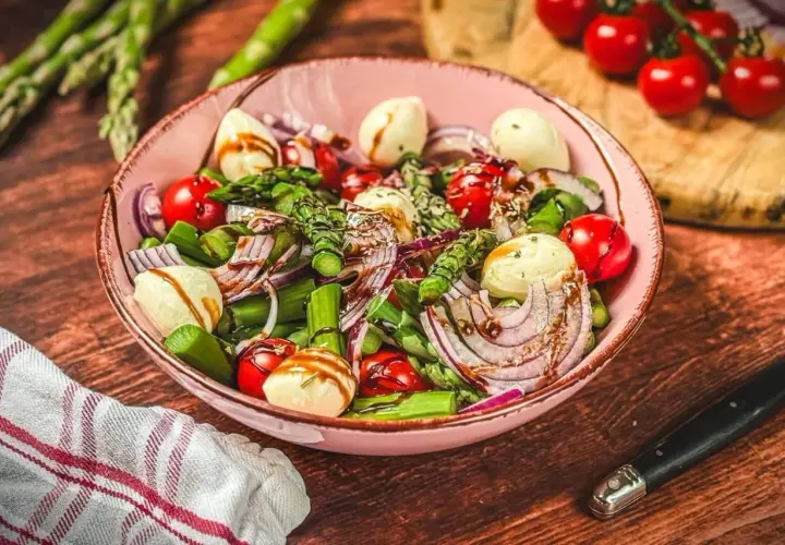 Ein frischer Spargel Tomaten Salat mit Mozzarella und roten Zwiebeln, beträufelt mit Balsamico.