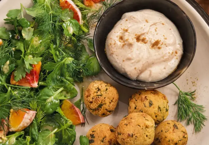 Falafel mit frischem Salat und einem cremigen, orientalischen Dip. Ein Genuss für jeden Gaumen!