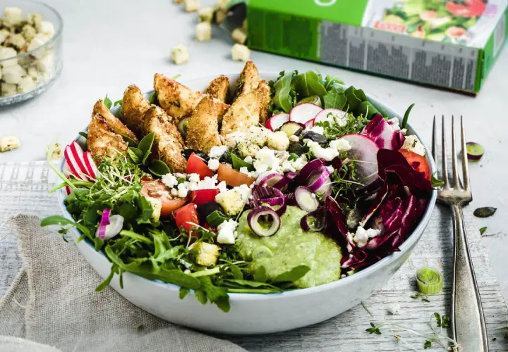 Bunter Salat mit knusprigen Kartoffelspalten, Feta, Radieschen und cremiger Avocado-Dip.