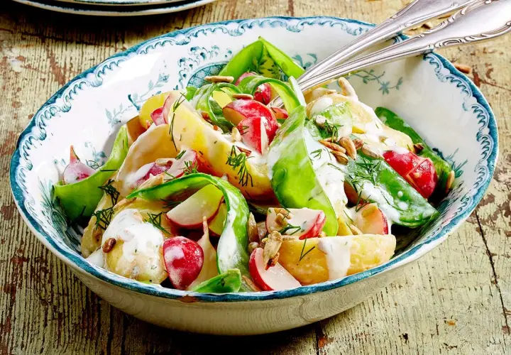 Kartoffelsalat mit Radieschen, Gurke und Dill, verfeinert mit einer cremigen Sauce und Sonnenblumenkernen. Ein frischer Genuss!
