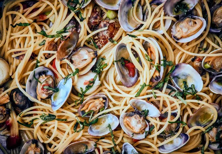 Spaghetti mit Muscheln, ein köstliches Gericht mit zarten Muscheln und perfekt gekochten Nudeln, garniert mit frischen Kräutern.