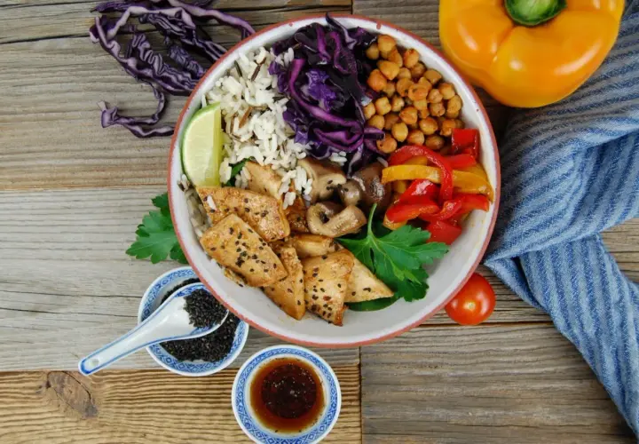 Bunter Bowl mit Reis, Hähnchen, Gemüse und Kichererbsen. Perfekt, um eine leckere bowl sauce selber machen.