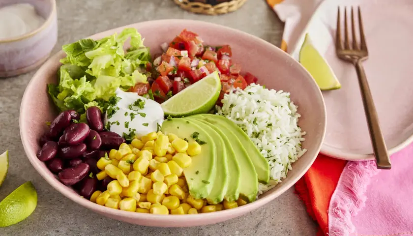Buntes Burrito Bowl Rezept mit Reis, Bohnen, Mais, Avocado, Salsa und Salat. Ein köstliches und gesundes Gericht.
