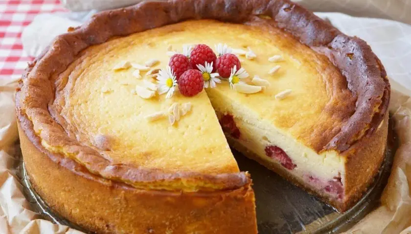 Ein köstlicher Kuchen mit Mascarpone und Himbeeren, garniert mit Mandelsplittern und frischen Beeren.