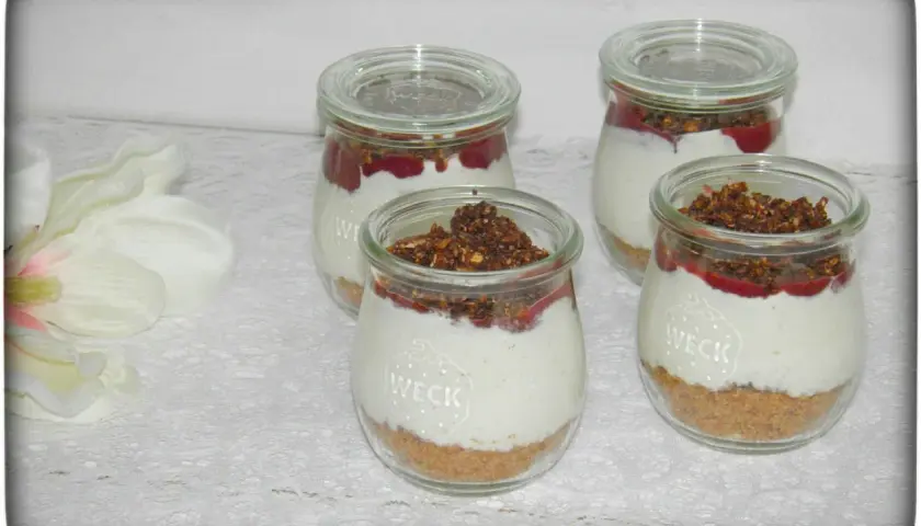 Vier leckere Nachtisch im Glas mit Müsli-Boden, cremiger Füllung und Fruchtpüree.