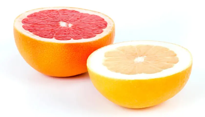 Zwei Hälften von Grapefruits, eine rote und eine gelbe, zeigen, wie man eine Grapefruit schneidet.