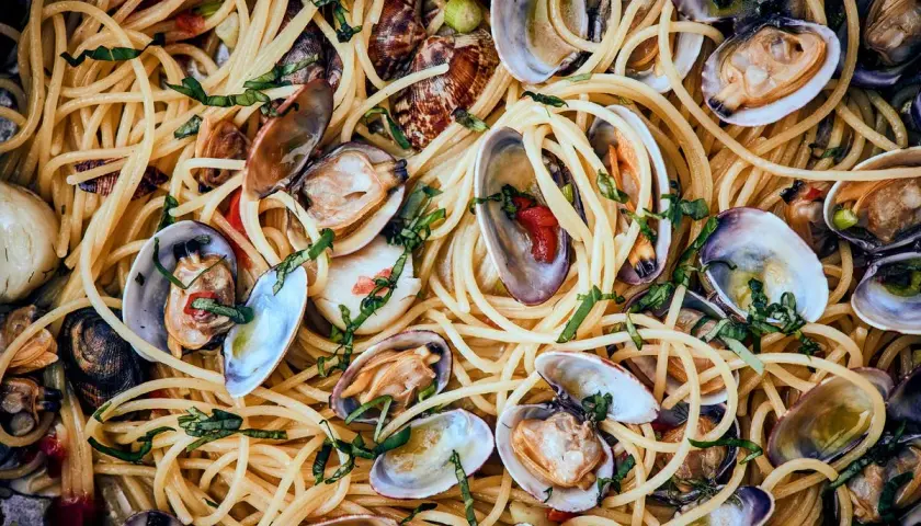 Spaghetti mit Muscheln, ein köstliches Gericht mit zarten Muscheln und perfekt gekochten Nudeln, garniert mit frischen Kräutern.