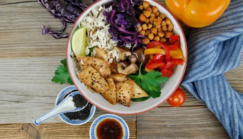 Bunter Bowl mit Reis, Hähnchen, Gemüse und Kichererbsen. Perfekt, um eine leckere bowl sauce selber machen.
