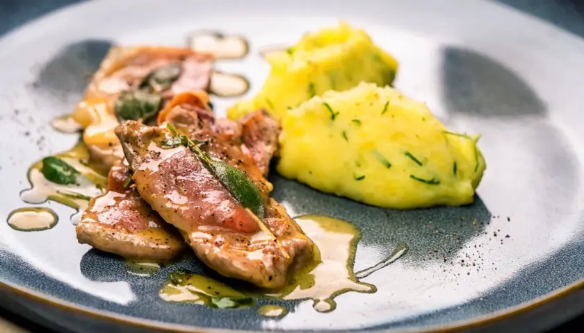 Saltimbocca alla Romana Rezepte: Zarte Kalbsschnitzel mit Salbei und Schinken, serviert mit cremigem Kartoffelpüree.