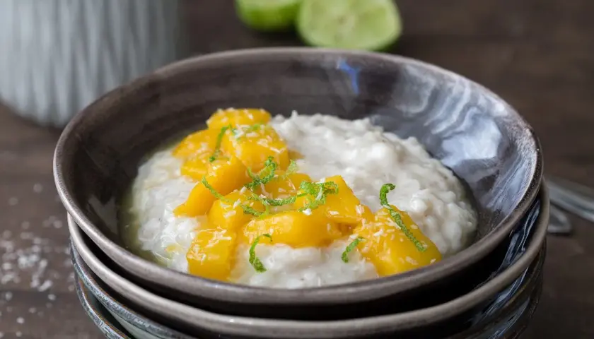 Cremiger Milchreis mit süßen Mangostücken und Kokosraspeln, eine köstliche Variante von Mango Sticky Rice.