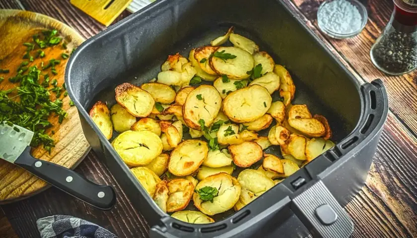 Goldbraune bratkartoffeln im Airfryer, garniert mit frischer Petersilie. Perfekt als Beilage oder Snack.