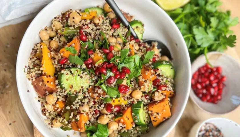 Bunter Quinoa-Salat mit Süßkartoffeln, Kichererbsen und Granatapfelkernen. Ein gesundes Gericht, das sich gut für Bowl-Rezepte eignet.