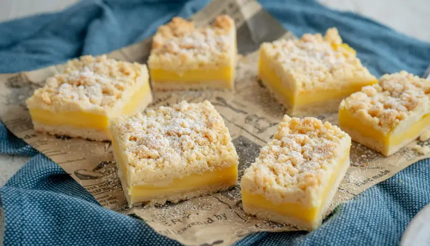 Sechs rechteckige Kuchenstücke mit gelber Füllung und knusprigen Streuseln. Boden und Streusel sind aus dem gleichen Teig, wie bei einem klassischen Streuselkuchen.