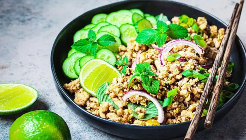 Würziges Laab Gai Rezept: Hackfleisch mit Gurkenscheiben, Minze, Limette und Zwiebelringen in einer Schüssel, bereit zum Genießen.