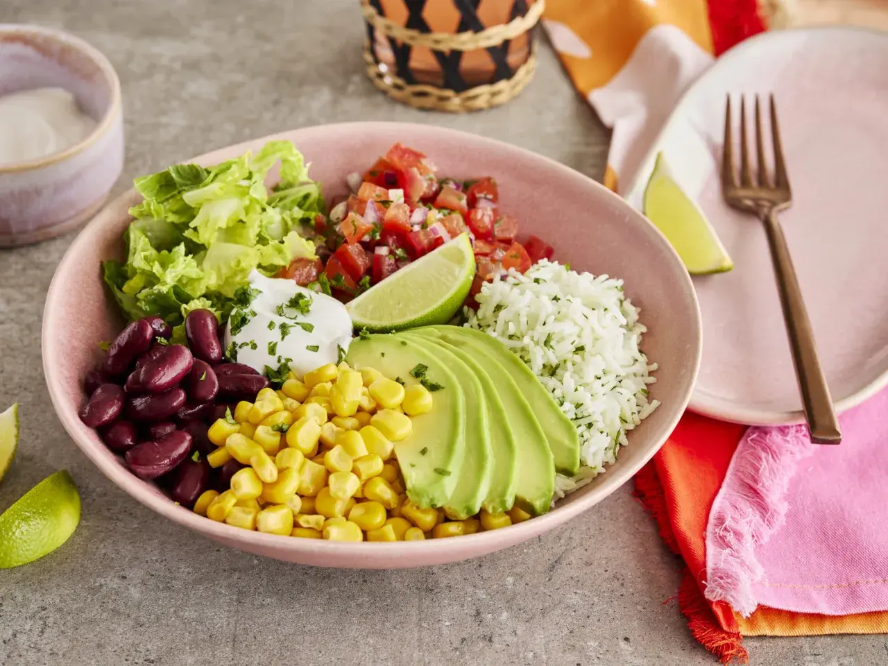 Buntes Burrito Bowl Rezept mit Reis, Bohnen, Mais, Avocado, Salsa und Salat. Ein köstliches und gesundes Gericht.