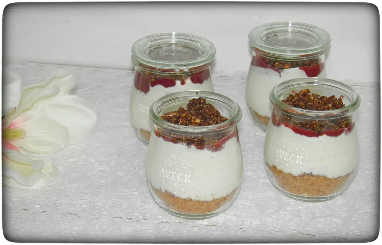 Vier leckere Nachtisch im Glas mit Müsli-Boden, cremiger Füllung und Fruchtpüree.