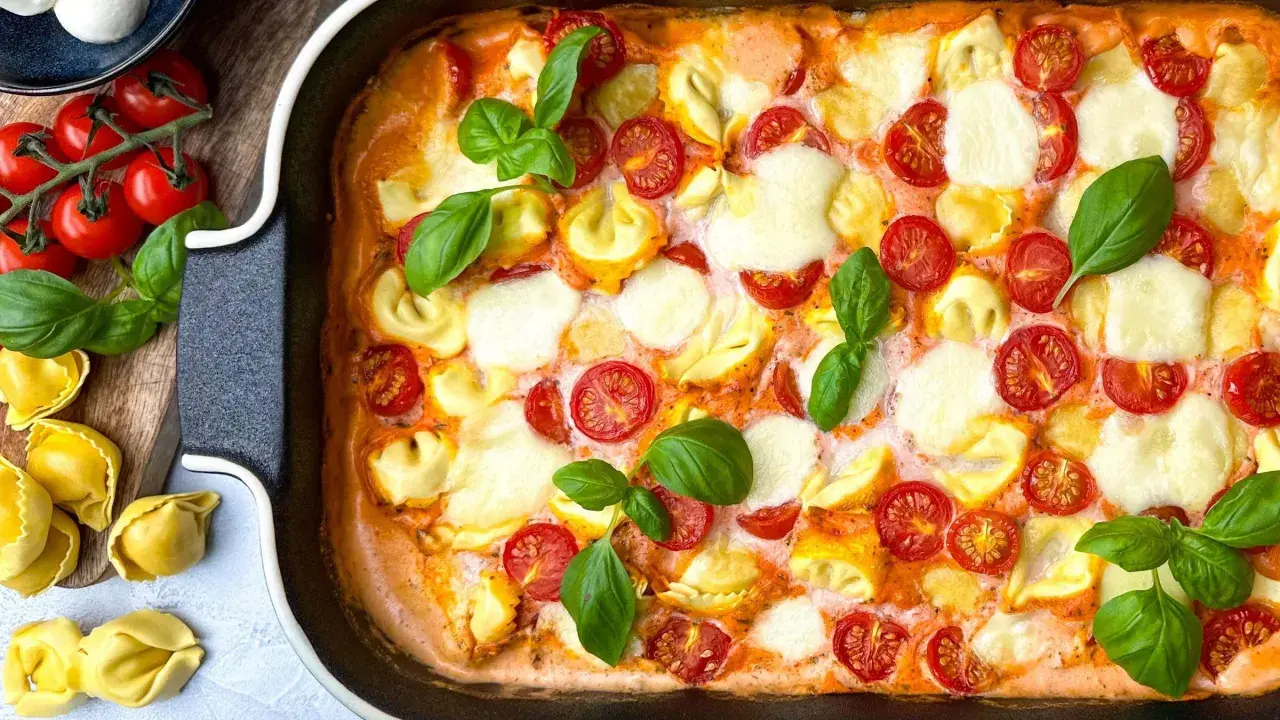 Ein köstlicher Tortellini-Auflauf mit Kirschtomaten und Mozzarella, garniert mit frischem Basilikum. Ein einfaches und schnelles Rezept für jeden Tag.