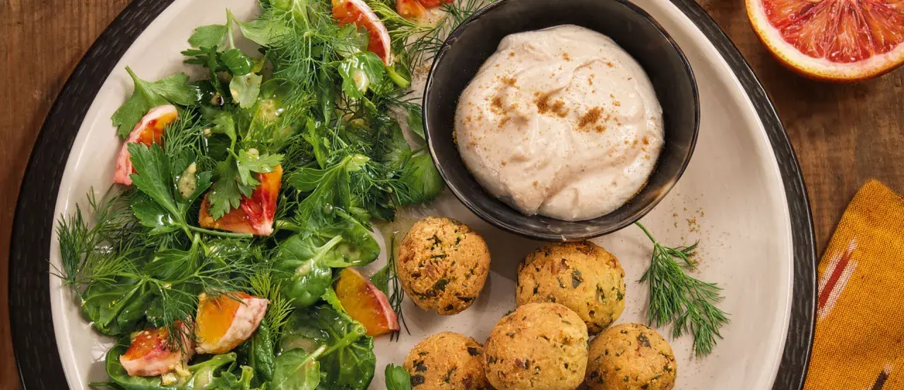 Falafel mit frischem Salat und einem cremigen, orientalischen Dip. Ein Genuss für jeden Gaumen!